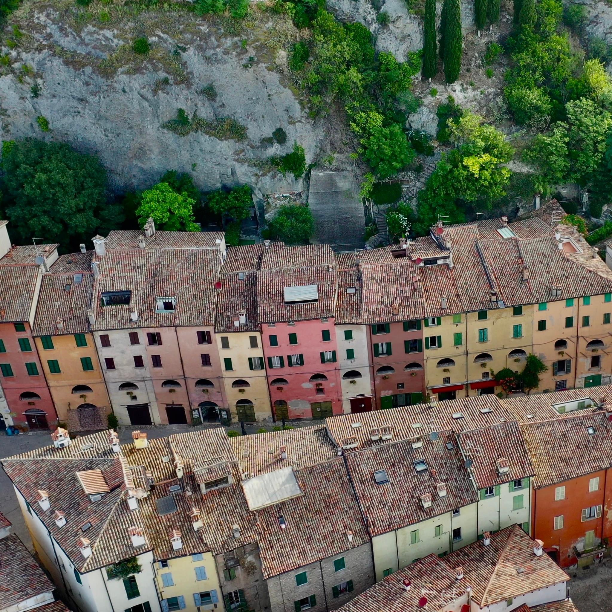 Brisighella, uno dei borghi più belli dell'Emilia-Romagna caratterizzato nella via principale da villette a schiera di diversi colori e costruite su crespi di roccia gessosa.
