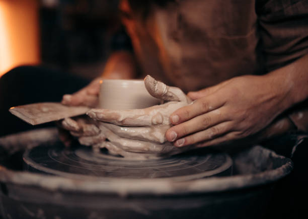 Una coppia che da forma a un vaso durante un laboratorio di ceramica